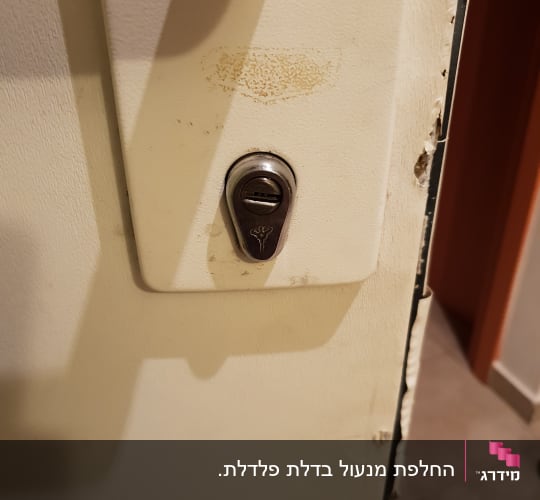 מנעול כסוף מותקן על דלת לבנה